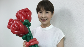 バルーンで作ったチューリップの束を持つ50代の素敵な女性