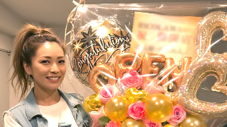 色とりどりのバルーンの束を持つ30代の女性